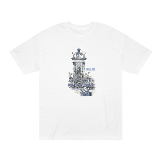 A white short-sleeve crewneck t-shirt featuring a detailed blue and gray graphic print of the Barcelona Cathedral bell tower and a small motorcycle in the foreground.